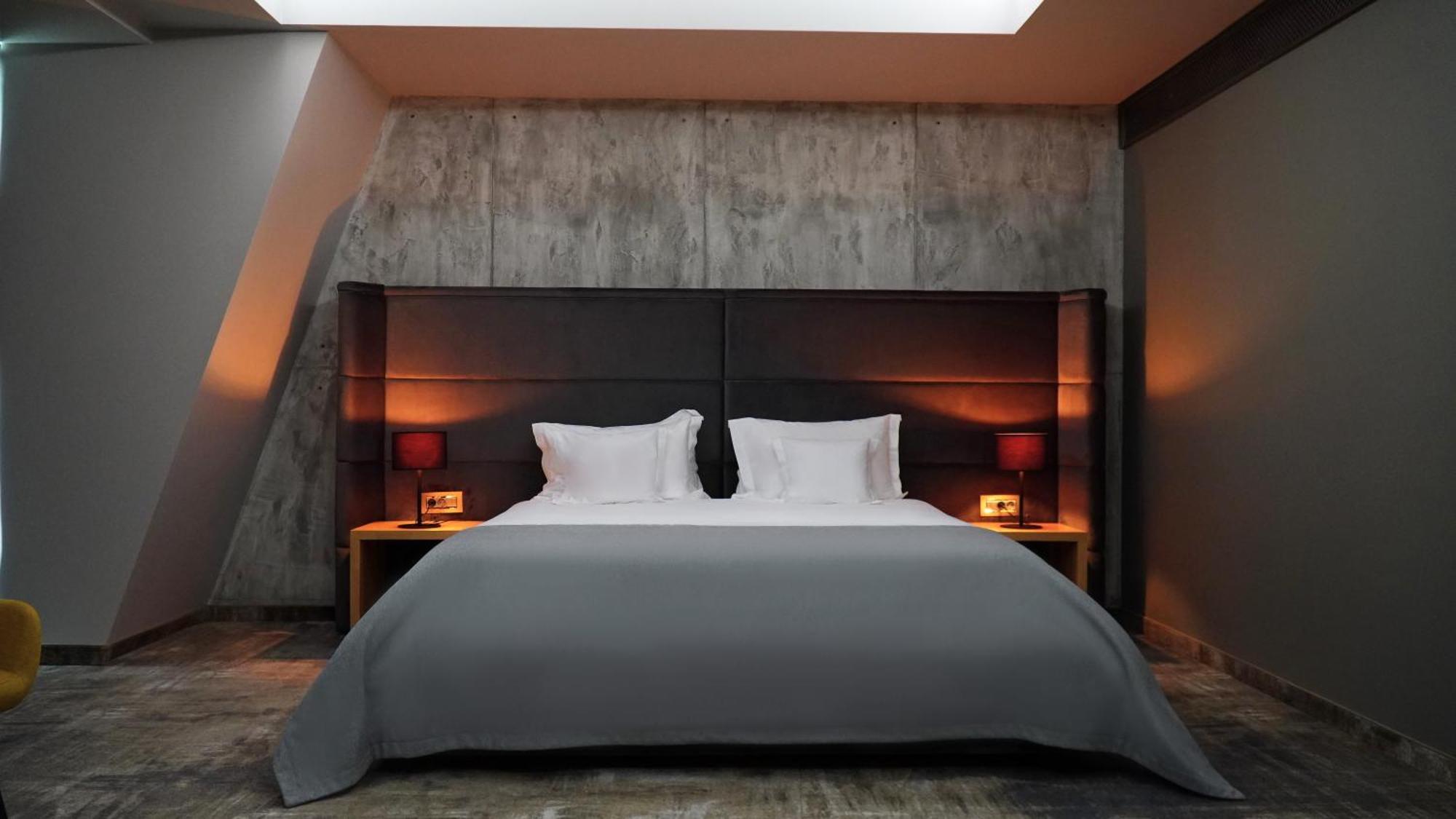 Aniroc Signature Hotel Arad Esterno foto A bed with a duvet